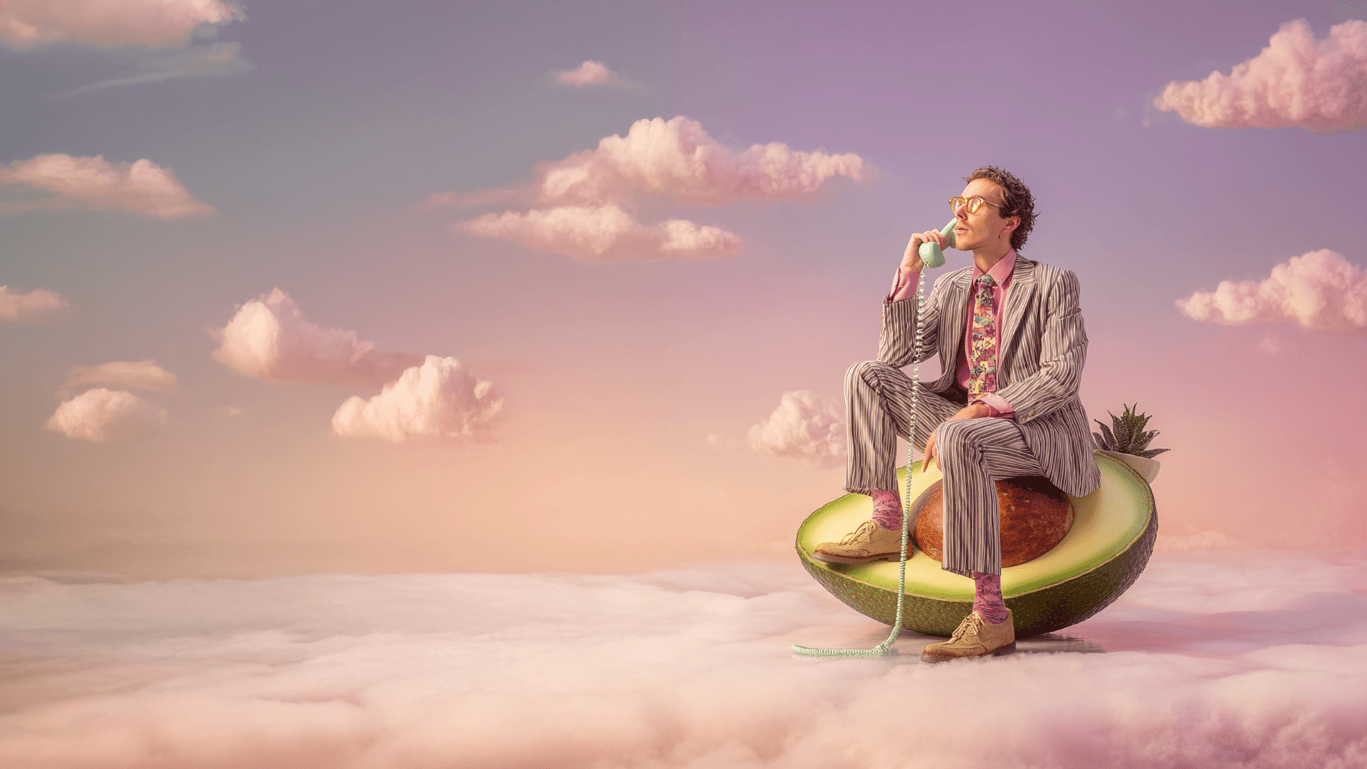 Hombre en traje de rayas sentado sobre un aguacate gigante entre nubes rosadas